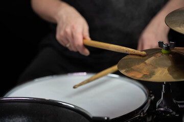 Professional drum set closeup. Man drummer with drumsticks playing drums and cymbals, on the live...