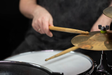 Professional drum set closeup. Man drummer with drumsticks playing drums and cymbals, on the live...