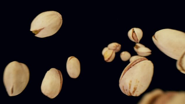 Super slow motion of falling pistachio on black background. Filmed on high speed cinema camera, 1000fps.