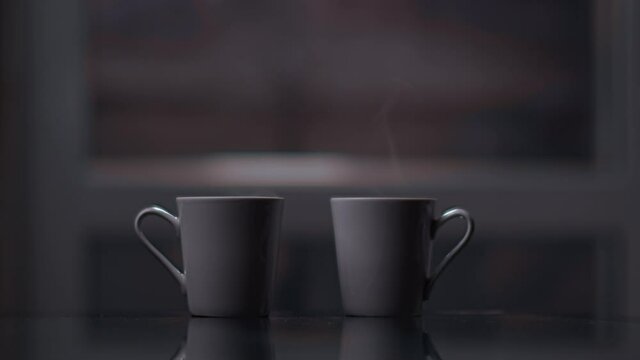two cups in a room with steam, mugs are waiting for their owners for a good cozy evening together