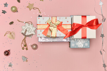 Top view of gifts in bright wrapping paper. The concept of a Christmas gift. Pink background.