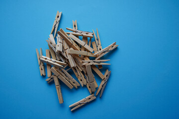 Wooden clothespin isolated on a blue background. The clothespin is a fastener used to dry clothes.