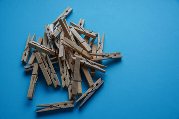Wooden clothespin isolated on a blue background. The clothespin is a fastener used to dry clothes.