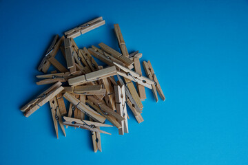 Wooden clothespin isolated on a blue background. The clothespin is a fastener used to dry clothes.