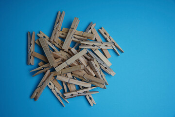Wooden clothespin isolated on a blue background. The clothespin is a fastener used to dry clothes.