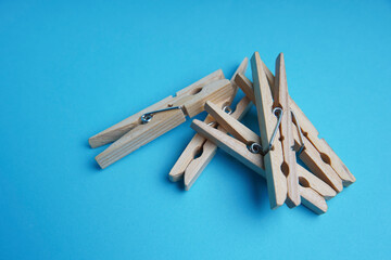 Wooden clothespin isolated on a blue background. The clothespin is a fastener used to dry clothes.