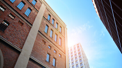 Fototapeta na wymiar Revitalized red brick building and modern office building. Rising sun on the horizon.