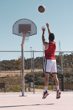 young athlete jumps to shoot a triple in a basketball hoop