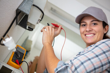 female electrician using multimeter to test an appliance