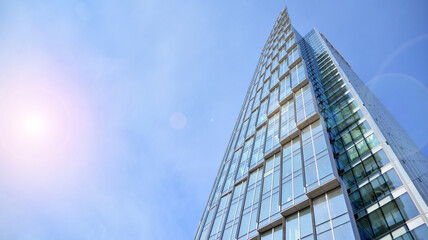 Downtown corporate business district architecture. Glass reflective office buildings against blue sky and sun light. Economy, finances, business activity concept. Rising sun on the horizon.