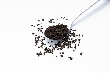 black tea granules isolated on white background. design element. indian beverage tea on spoon cut out