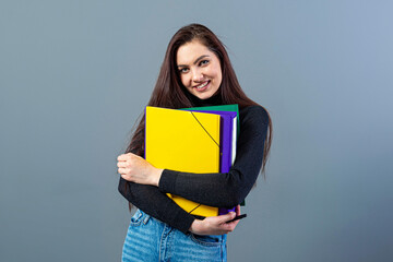 fashionable female holding a colorfuls folders with documents, isolated on dark background