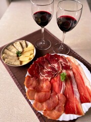 Tasty cheese and meet slices with red wine for a romantic dinner 