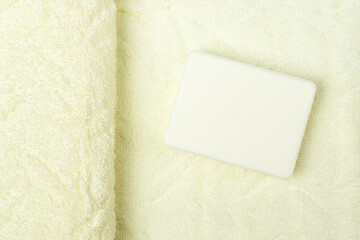 White soap bar  on the background of soft terry towel, copy space. Hygiene and body care.