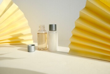 Set of two bottles (Body and hair care set) on geometrical background with paper fans. Mockup for...