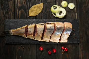 Dutch raw herring with onions and spices on serving board. The idea of snack for a street cafe or restaurant