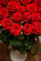 Beautiful red rose flower heads, photographed from above on brown wooden table. Spring flowers. Wedding, women's day, mothers day and valentines day background. Selective small depth of field.