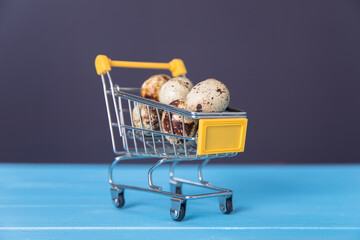 Raw quail eggs in mini shopping cart