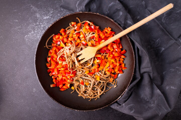 Noodles with seaweed and vegetables. Asian cuisine. On a blue background. Horizontal orientation.
