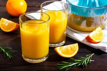 A couple of glasses of orange juice in the sunlight. A refreshing drink on a hot day.
