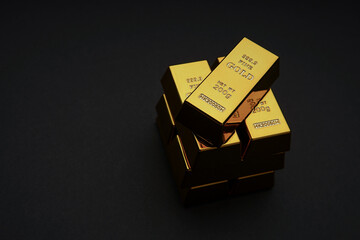 A pile of gold bar a black background. Shiny precious metals for investments or reserves.