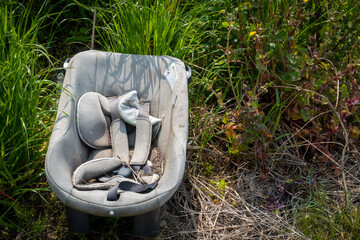 不法投棄されたチャイルドシートの写真。環境問題のイメージ。