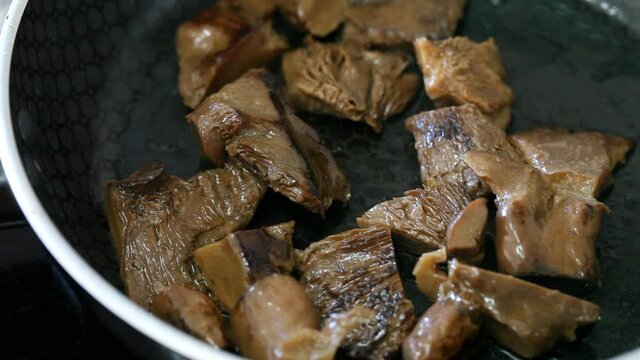 Fried mushrooms (Lactarius deliciosus) in frying pan. Roasting the chopped mushrooms in oil