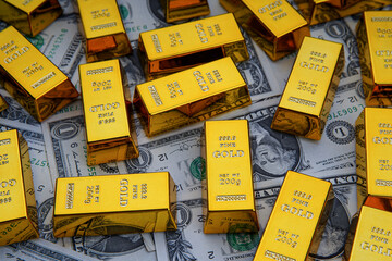 Shiny gold bars and american dollar banknotes close up. Shiny precious metals for investments or reserves. Bank image and photo.