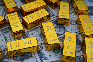 Shiny gold bars and american dollar banknotes close up. Shiny precious metals for investments or reserves. Bank image and photo.