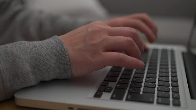 コンピュータを操作する男性の手のアップ