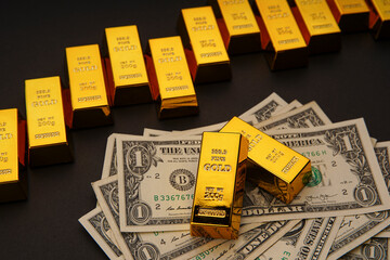 Shiny gold bars in a row and US dollar banknotes. Shiny precious metals for investments or...
