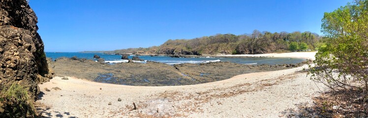 Panoramic view of a rocky beach on a sunny day