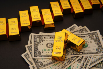Shiny gold bars in a row and US dollar banknotes. Shiny precious metals for investments or reserves. Bank image and photo.