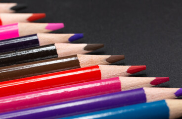 Naklejka premium Close-up of colored pencils slanted together with black background and some copy space for school and art