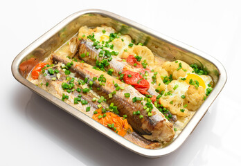 hake fish baked with vegetables close view, baking tray with tomatoes, broccoli and spices, home cooking