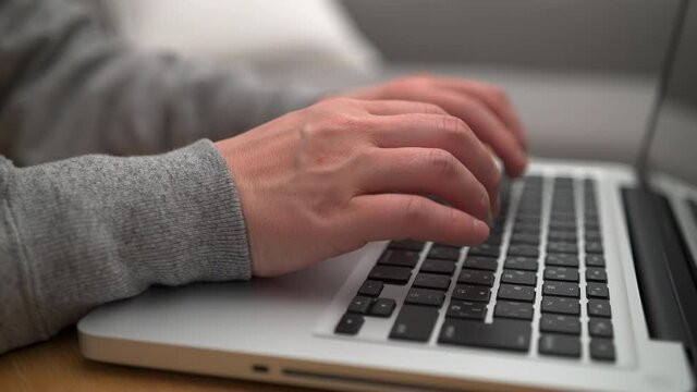コンピュータを操作する男性の手のアップ