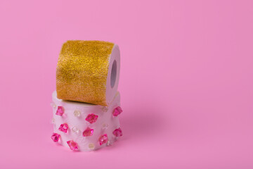 Creative idea with toilet paper with diamonds and glitter on a pastel pink background.