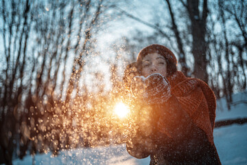 Fototapeta na wymiar beautiful happy female playing with snow and have fun outdoor in winter park