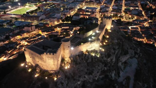 Aerial view of illuminated cityscape of Castalla in autumn evening, province of Alicante, Spain. High quality 4k footage
