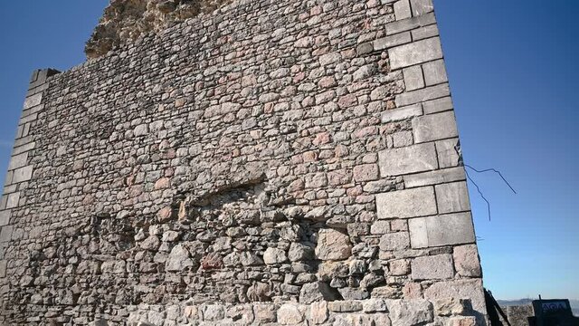 Close up view of old stone tower and defensive thick walls in Smlednik castle, Slovenia. Ruins of renovated castle on hilltop. Tourist attraction. Tilt down, wide angle