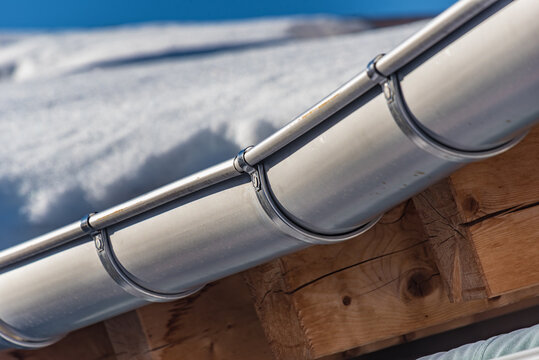 Regentraufe am schneebedeckten Dach