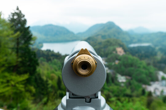 Binoculars looking out to beautiful mountains and lakes - Powered by Adobe
