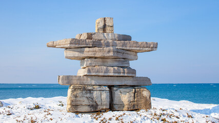 A giant Inukshuk stands overlooking Georgian Bay at Collingwood's Sunset Point Park. A monument in...