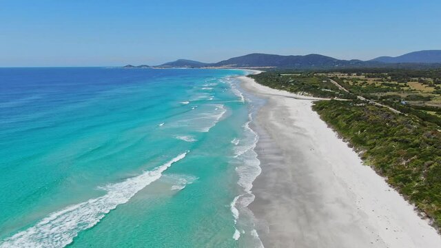 Stunning high angle aerial panoramic drone footage of Denison Beach, Denison River and A3 Tasman Highway just north of the village of Bicheno on the east coast of Tasmania, Australia on a sunny day.