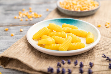 Jelly corn candies on gray wooden background. close up, side view, selective focus.