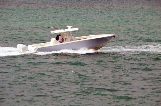Light blue with white trim p[en fishing boat powered by four outboard engines.