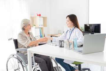 Obraz premium Asian doctor talk with old female patient about disease symptom, they holding hand together, elderly health check up, happiness hospital, hand in hand