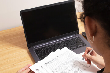 Session to set up bills and bills for tax day at a table with a calculator and a laptop with a...