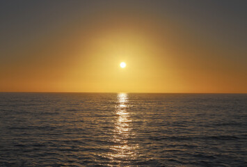 View of the sun setting over the ocean at Sunset Cliffs in California.