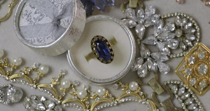 Antique ring with blue gemstone in box and jewel set. Beautiful fashion and vintage jewelry with precious shiny stones, pearls and diamonds for women. Background of Many yellow white gold and silver j